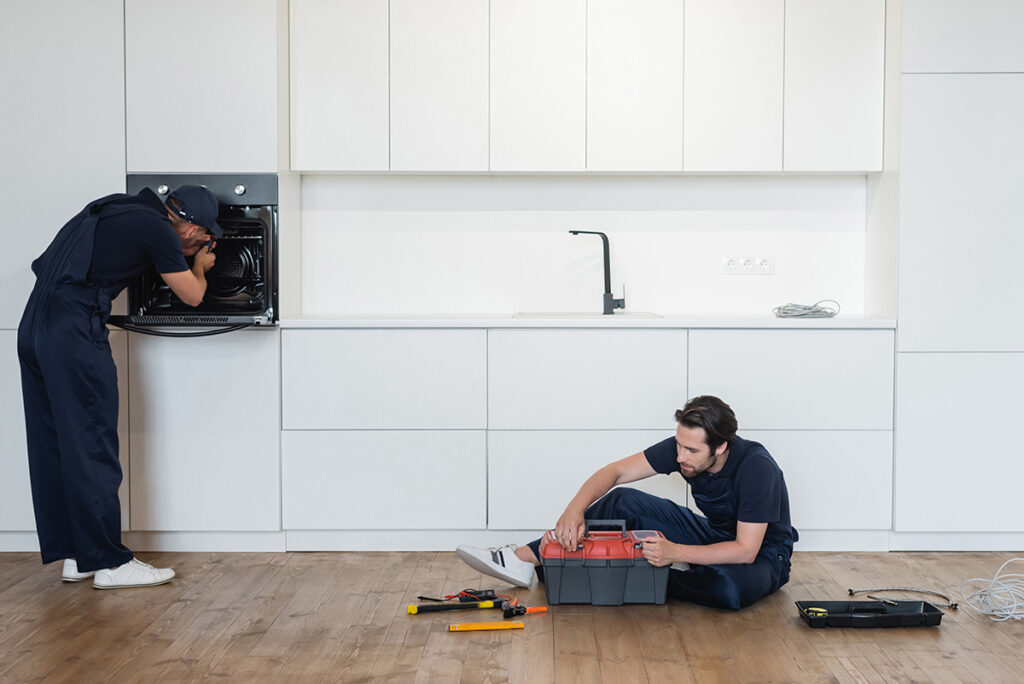 repairman fixing electric oven near