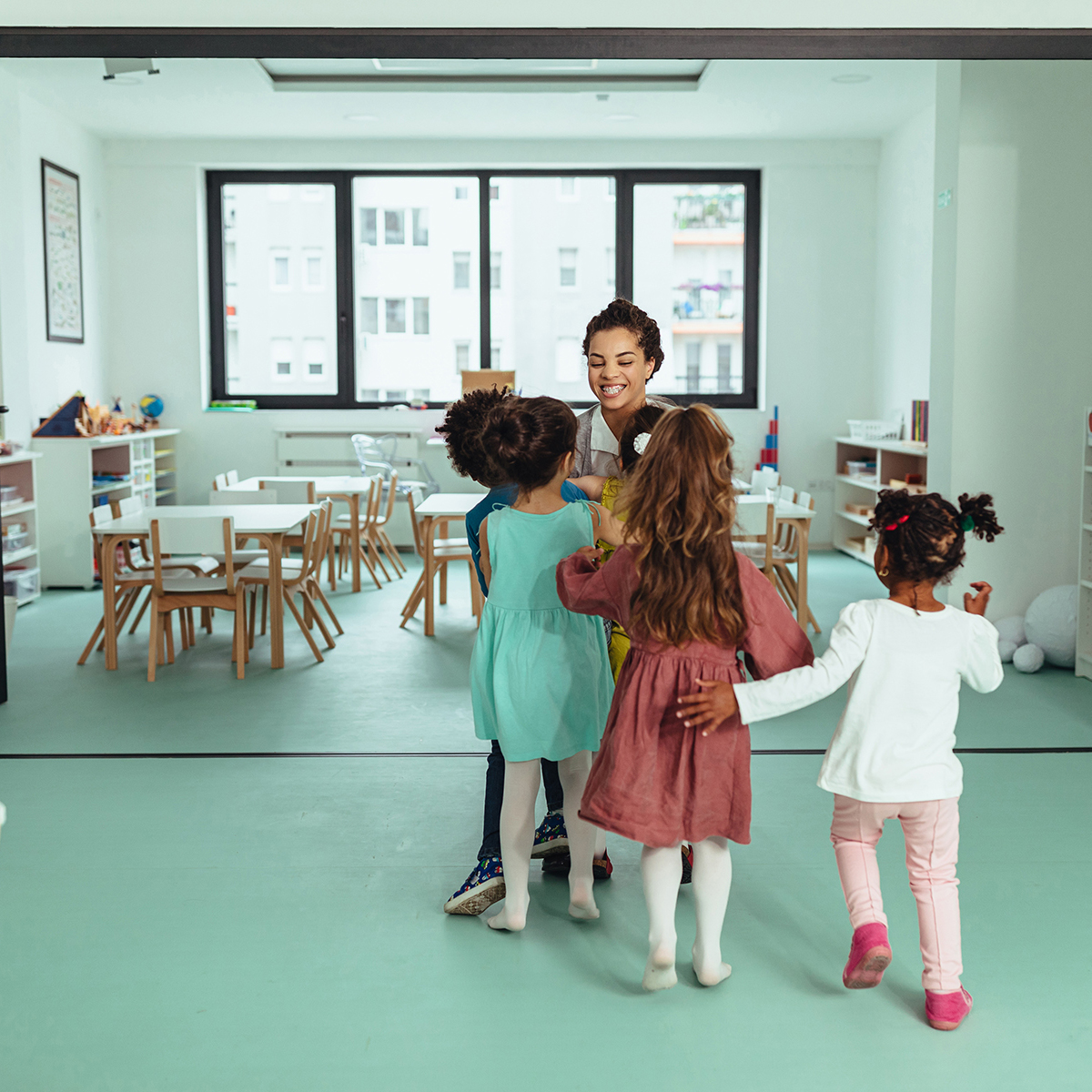 Teacher with children playing at kindergarten